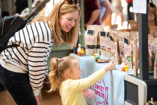 A mum and her young daughter select sweets at a stall at the Holkham Spring Market.